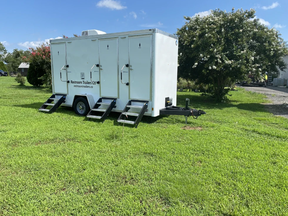 Restroom trailer with steps lowered at each of the three doors