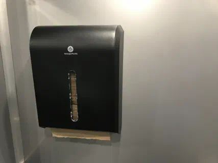 Paper towel dispenser mounted on the interior wall, kept stocked between services