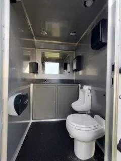 Interior showing the toilet, vanity, mirror, and window in one suite